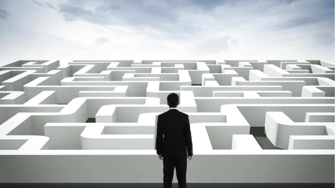 Ilustração mostra um homem parado diante da entrada de um labirinto