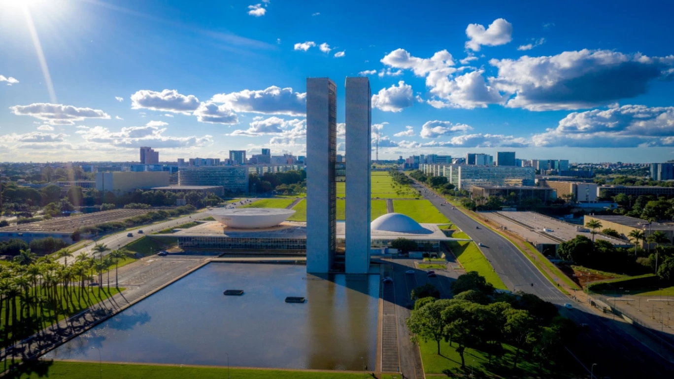 Imagem aérea do Palácio do Planalto em Brasília, com o Congresso ao fundo, em dia ensolarado.