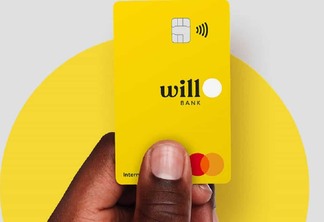 A mão de uma pessoa negra segura um cartão amarelo do Will Bank