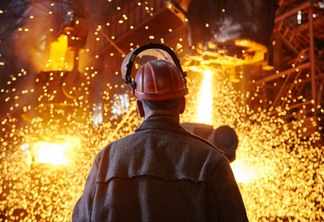 Trabalhador diante de caldeira em usina siderúrgica