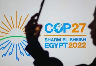 Silhueta de uma mulher diante do logotipo oficial da COP27
