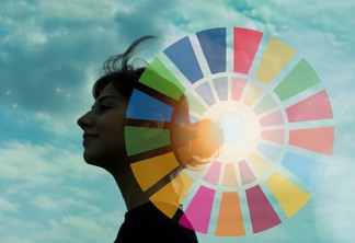 Mulher branca jovem com céu azul e nuvens ao fundo e um círculo representando os Objetivos de Desenvolvimento Sustentável sobreposto à imagem.