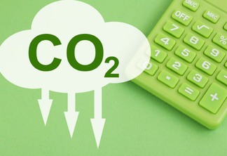 calculadora verde sob fundo verde com símbolo de co2 indicando redução