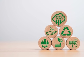 Conjunto de círculos de madeira com símbolos ligados à economia verde para simbolizar o conceito de redução de dióxido de carbono.
