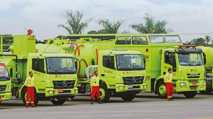 três caminhões verdes enfileirados cada um com um operador à frente