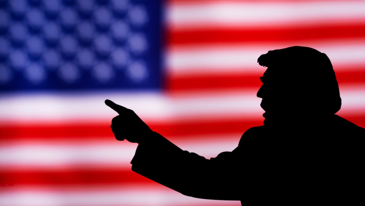 Silhueta do presidente Donald Trump diante de bandeira dos Estados Unidos Silhueta do presidente Donald Trump diante de bandeira dos Estados Unidos